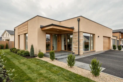 Pavillon clé en main moderne en enduit beige avec bardage bois, jardin aménagé et allée en gravier, vue extérieure grand angle