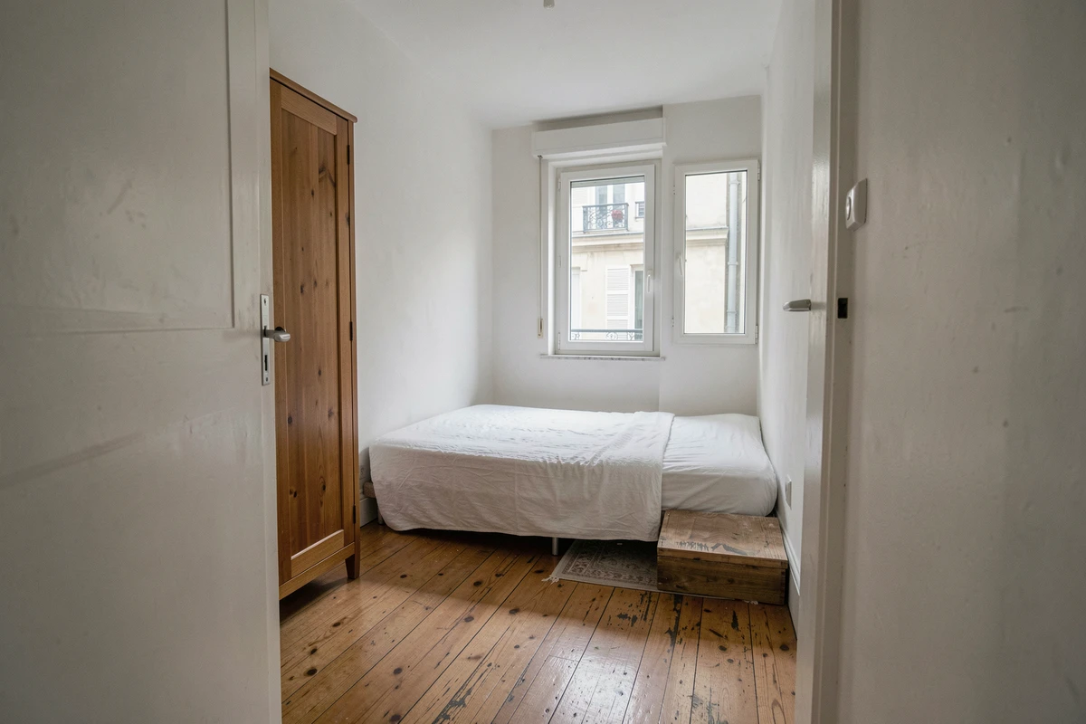 Petite chambre de 7 m² dans un appartement T2 parisien, illustrant la taille minimum d'une chambre selon la loi Carrez