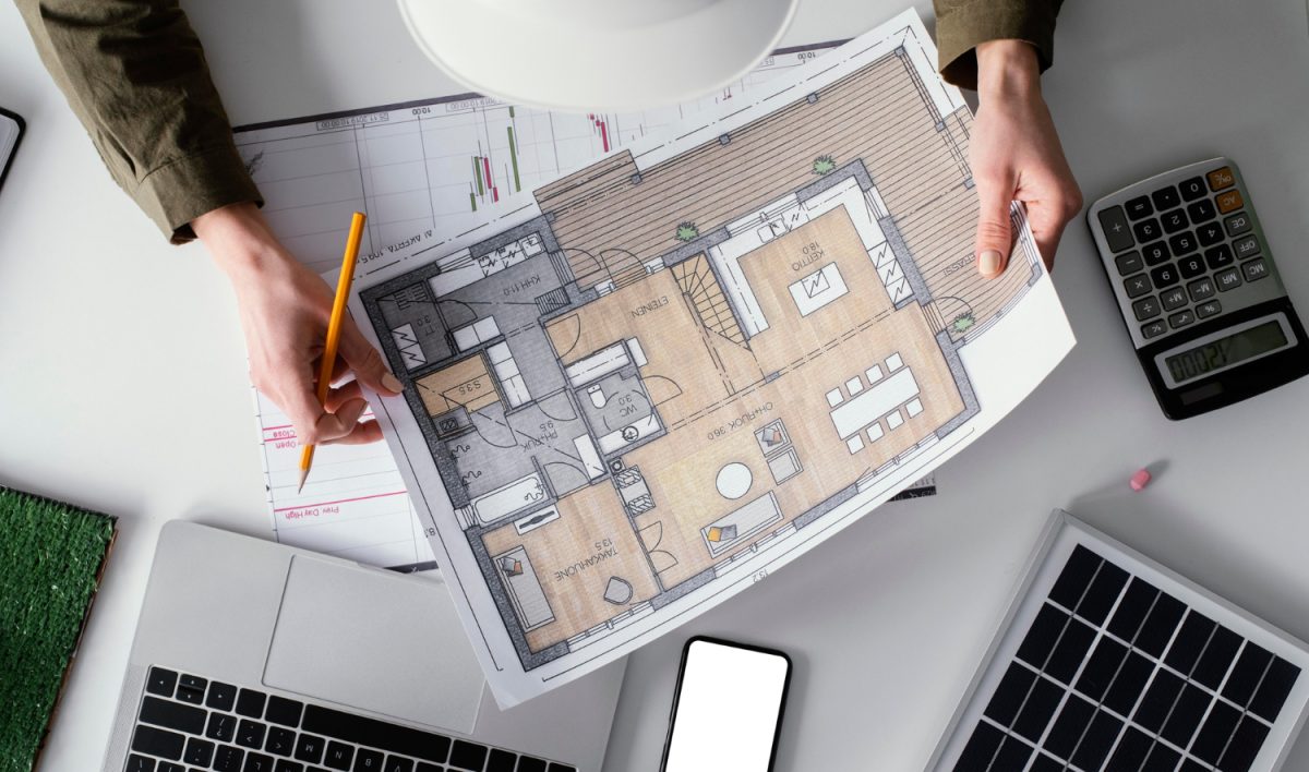 un constructeur est en train de dessiner les plans d'une future maison